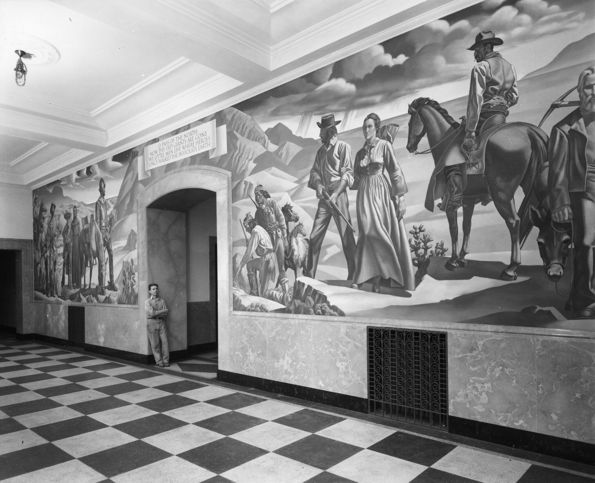 Tom Lea standing in front of the Pass of the North mural